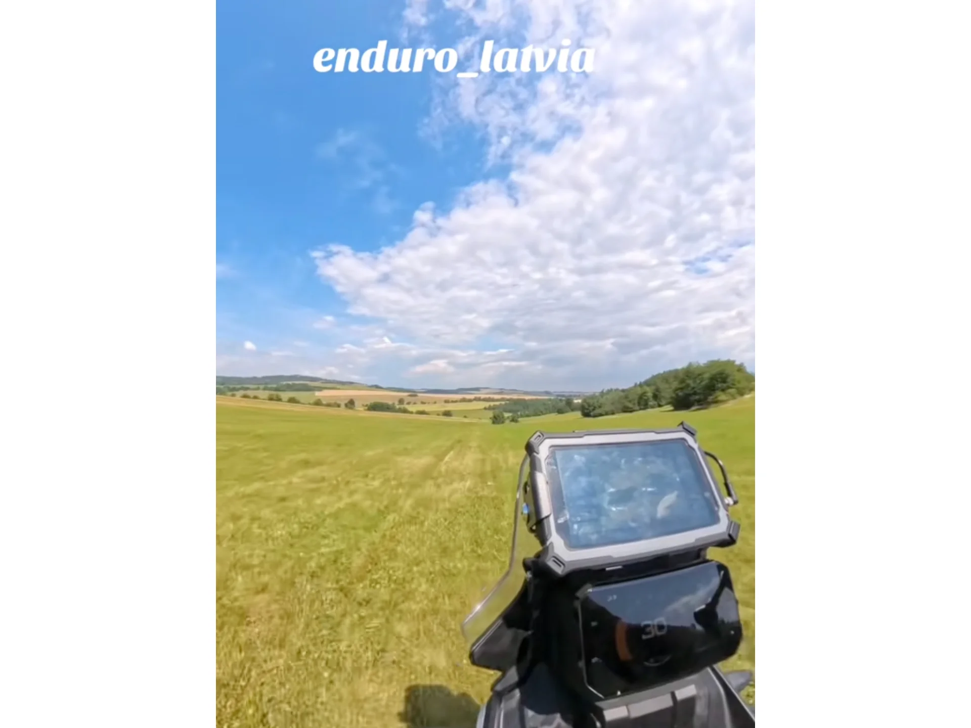Group of enduro riders on motorcycles following each other through forest trails